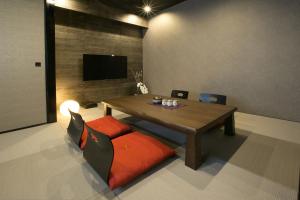 a dining room with a table and chairs and a television at Hotel Banister Kyoto in Kyoto