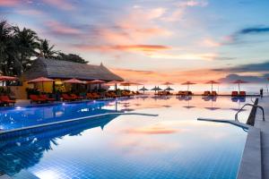 a swimming pool with a sunset in the background at Terracotta Resort & Spa in Mui Ne