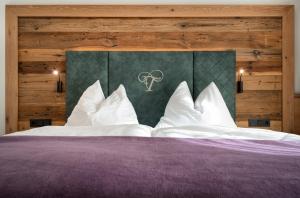 um quarto com uma cama grande e almofadas brancas em Der Tröpolacherhof Hotel & Restaurant em Tröpolach