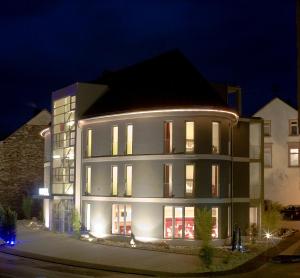 ein großes Gebäude in der Nacht mit Lichtern in der Unterkunft Hotel Moseldomizil in Mülheim an der Mosel