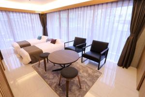 Un dormitorio con una cama y una mesa y sillas. en Tabinoteitaku Okinawa Naha, en Naha