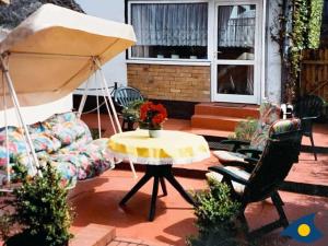 eine Terrasse mit einem Tisch und einem Sonnenschirm in der Unterkunft Haus Ückeritz Parterrewohnung in Ückeritz