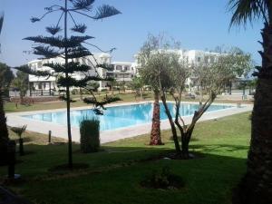 a resort with a swimming pool and a building at Bahia Golf Beach Apartement in Bouznika