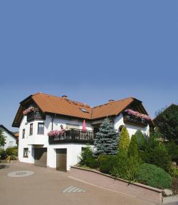 a white building with a balcony and a christmas tree at Gästehaus Klein in Hilders