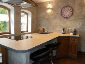 a kitchen with a counter and a clock on the wall at LE PIOU in Annecy