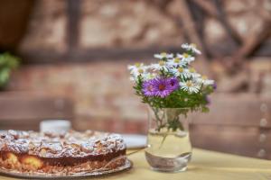 a vase with flowers and a cake on a table at Zum alten Hauptmann in Großfahner