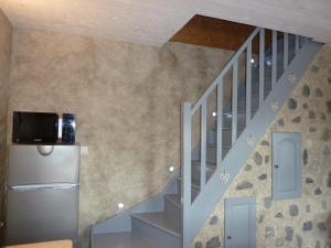 a room with a staircase with a tv on the wall at LE PIOU in Annecy