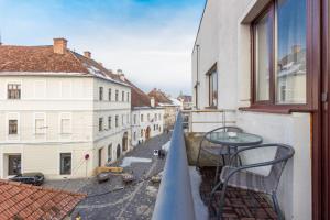 a balcony with a table and a view of a street at Corvin's Crib in Cluj-Napoca