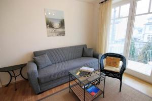 a living room with a gray couch and a chair at Haus Jahreszeiten by Rujana in Binz