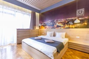 um quarto com uma cama grande e uma pintura na parede em Corvin's Crib em Cluj-Napoca