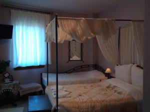 1 dormitorio con 2 camas y 2 ventanas en Guesthouse Kalosorisma en Tsagarada