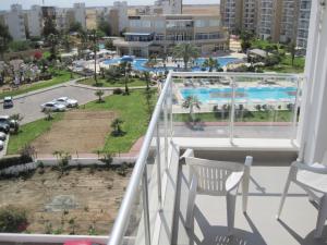 a balcony with two chairs and a view of a city at Angel's Apartment at Caesar Resort in Trikomo +46 photos