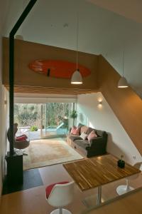 een woonkamer met een bank en een surfplank aan de muur bij O Vale in Ericeira