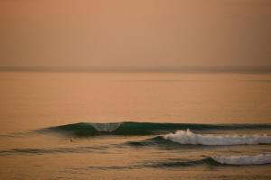 um surfista surfando uma pequena onda no oceano em O Vale na Ericeira