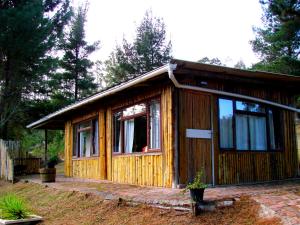a small wooden cabin with a large window at Hindthausen in Knysna