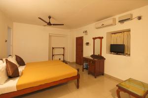 a bedroom with a bed and a television in it at Rossitta Wood Castle in Cochin
