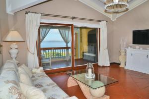 a living room with a couch and a glass table at Emeraldway - Appartamento Stylish & De Luxe Cala del Faro - Porto Cervo in Porto Cervo