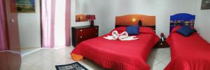 a bedroom with a red bed with two white towels on it at Abbronzatissima in Trapani