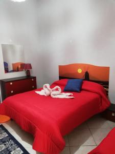 a bedroom with a red bed with towels on it at Abbronzatissima in Trapani