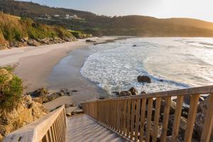 a view of the beach from a wooden balcony at Hotel Santa Catalina by Bossh Hotels in A Coruña