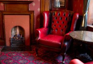 una silla roja en una habitación con chimenea en The Market Inn en Brighton & Hove