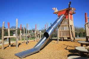 a slide in a park with a playground at Les Pagodes de Beauval in Saint-Aignan