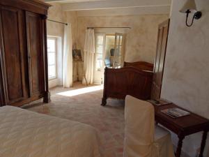 een slaapkamer met een bed, een tafel en een bureau bij Le Côté d'Elle in Niozelles +17 foto's