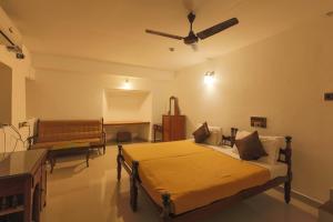 a bedroom with a bed and a ceiling fan at Rossitta Wood Castle in Cochin