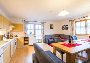 a kitchen and a living room with a table and chairs at Appartement Achenhof in Bad Hofgastein