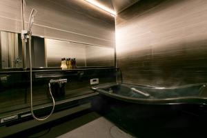 a bathroom with a bath tub and a sink at Hotel Banister Kyoto in Kyoto