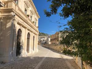 une rue vide dans une ville avec un bâtiment dans l'établissement Palazzo Favacchio - Patanè, à Scicli