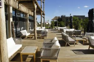 een rij stoelen en tafels op een houten terras bij Les Hauts de Beauval in Saint-Aignan