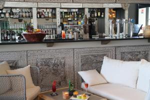 a bar with a white couch and a counter at Les Hauts de Beauval in Saint-Aignan +40 photos