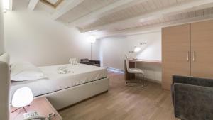 a bedroom with a bed and a desk in a room at Scicli Albergo Diffuso in Scicli