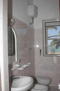 a bathroom with two toilets and a sink and a mirror at Albergo 2 Pini in Rodi Garganico