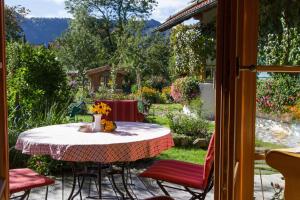 a table with a vase of flowers on a patio at Suzanne's B&B & Gardens in Füssen