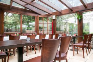 een eetkamer met houten tafels en stoelen bij Hotel Diana in Schönwalde