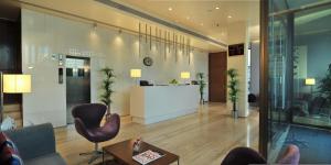 an office lobby with chairs and a reception desk at Marasa Sarovar Portico -Rajkot in Rajkot