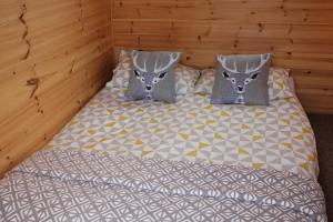 a bedroom with a bed with two pillows and a bed at Howe of Torbeg in Ballater