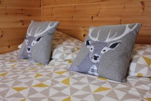 two pillows with deer heads on a bed at Howe of Torbeg in Ballater