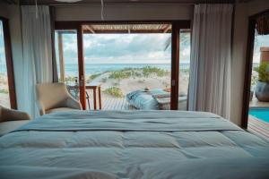 Schlafzimmer mit einem Bett und Strandblick in der Unterkunft Eclectic Beach Retreat in Cabo Nhamua