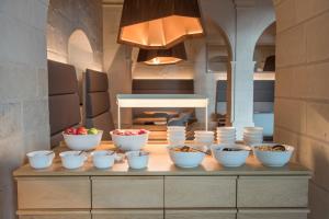 
a kitchen filled with bowls and plates of food at Fontevraud L'Hôtel in Fontevraud-l'Abbaye
