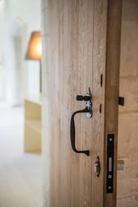 a close up of a wooden door with a handle at Fontevraud L'Hôtel in Fontevraud-l'Abbaye