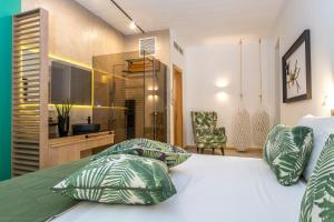 a bedroom with a bed with green and white pillows at Kalamaki Luxury Suites in Kalamaki