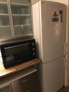a kitchen with a microwave and a refrigerator at Gran Apartamento, un lujo en playa El Saler - Valencia in El Saler