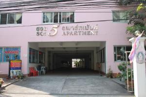 a white building with a tunnel leading into it at Soi 5 Apartment in Pattaya
