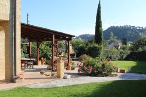 - un pavillon avec une table et des chaises dans un jardin dans l'établissement Casa Donella, à Poggibonsi