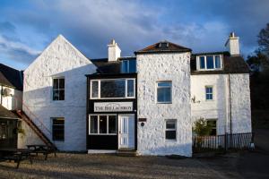 a white building with a sign on the front of it at The Bellachroy Hotel in Dervaig
