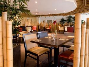 托基TLH Carlton Hotel - TLH Leisure, Entertainment and Spa Resort的用餐室配有桌椅和植物
