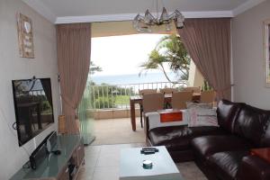 uma sala de estar com um sofá e uma televisão em Our Happy Place em Durban